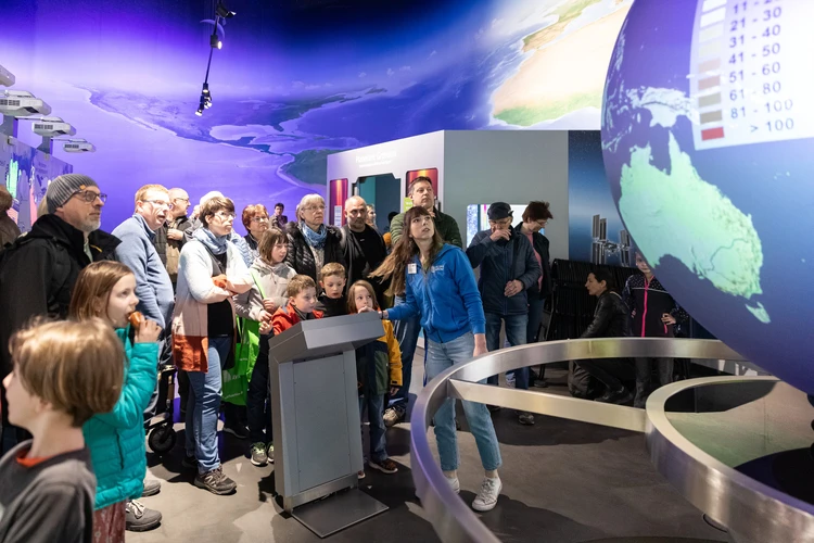 Auf dem Bild ist eine Gruppe von Besucher:innen in einer Ausstellung zu sehen.