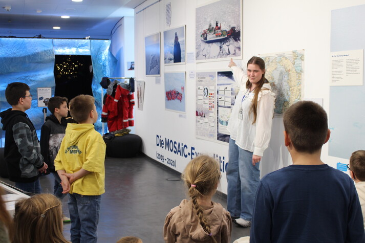Mitarbeiterin des Bildungsteams mit Kids bei der Rallye in der Sonderausstellung.